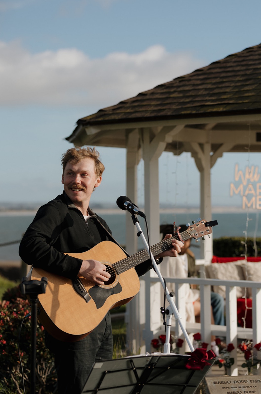 Shawn Chasten playing guitar in warm lantern light